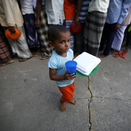 A Rohingya child receives food during the break of fasting on the first day of the Muslim fasting month, in a refugee camp in Aceh, Indonesia. Photo: EPA