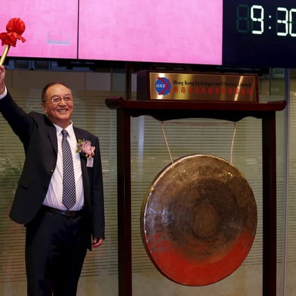 Liu Chuanzhi, chairman of Legend Holdings, hits the gong during the debut of the company on the Hong Kong stock exchange. Photo: Reuters