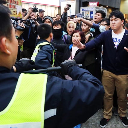 The defendant, Ng Lai-ying, used her chest to bump against the right arm of Chief Inspector Chan Ka-po as he dealt with her co-defendants during the chaotic protest in Yuen Long on March 1, 2015. Photo: Felix Wong