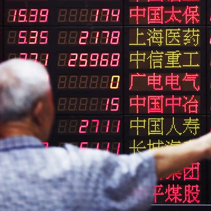 An investor looks at information displayed on an electronic screen at a brokerage house in Shanghai. Photo: Reuters