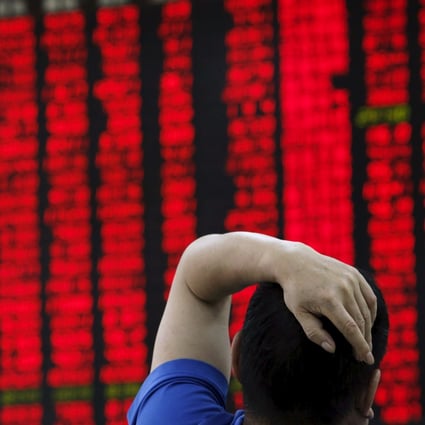 A man watches a board showing stock prices at a brokerage office in Beijing. Photo: Reuters