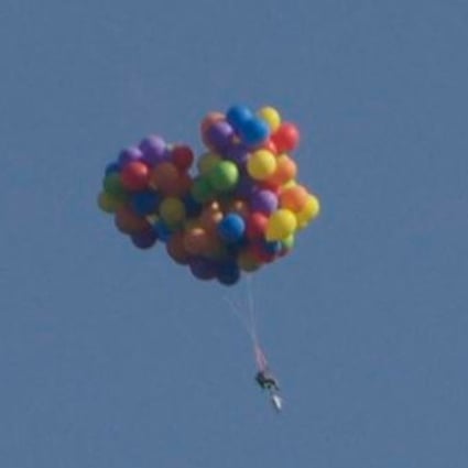 Up up and away... One brave Canadian takes to the sky in a balloon powered chair. Photo: SCMP Pictures