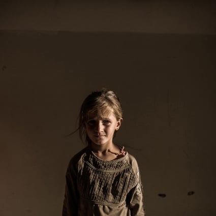 A Syrian refugee girl stands in a building in the Syrian Kurdish city of Amuda, after running away from clashes between regime forces and Islamic State. Photo: AFP