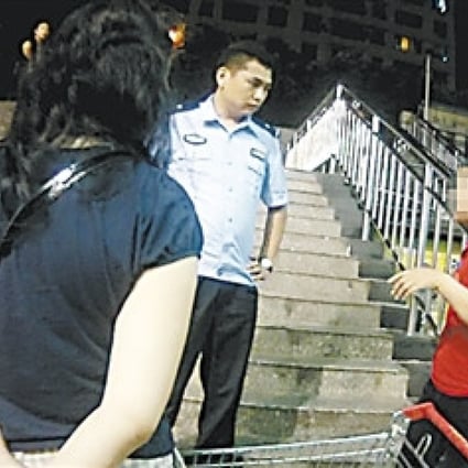 The mother, right, is cautioned for taking photos of supermarket employees without their permission. Photo: SCMP Pictures