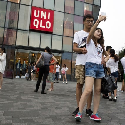 A couple take a selfie outside the Uniqlo flagship store where a steamy video was purportedly taken inside a fitting room in Beijing. The authorities are cracking down on home-made sex videos. Photo: AP