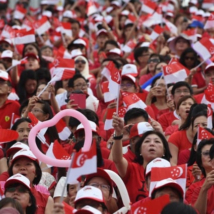 Thousands wave national flags during August 9 festivities. Photo: AFP