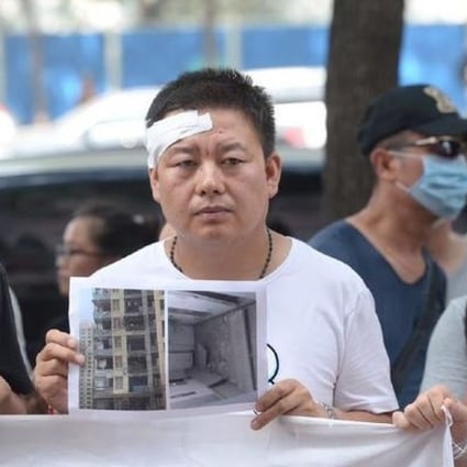 Frustrated owners from the Qihang Jiayuan residential compound demonstrate outside a press briefing. File Photo