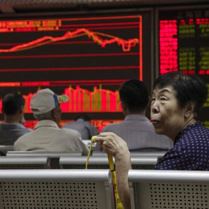 An investor looks up from her seat as stock data is displayed on an electronic board at a securities brokerage house in Beijing, China. Photo: EPA