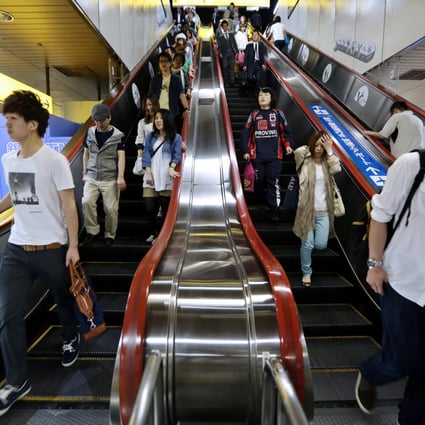 Japanese commuters ride escalators in a Sapporo train station. Photo: Bloomberg