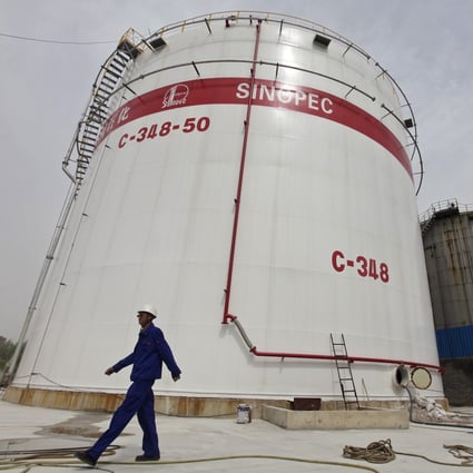 An employee walks past oil tanks at a Sinopec refinery in Wuhan, Hubei province. China aims to expand Communist Party leadership and governance in state firms at the same time. Photo: Reuters