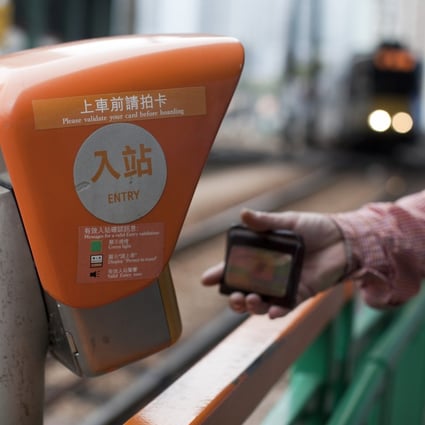 A commuter swipes his Octopus card before boarding an MTR light rail train in the Tin Shui Wai area of Hong Kong. Photo: Bloomberg