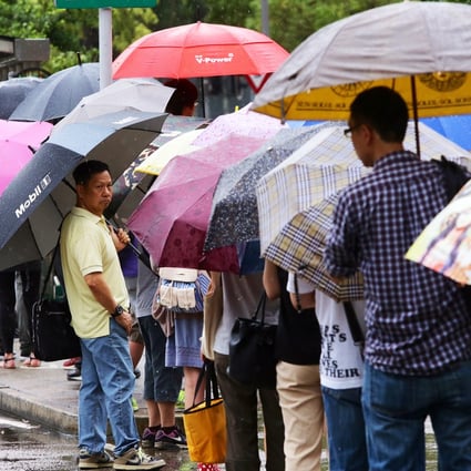 People queue for public transport in Ma On Shan during today's rainstorm. Photos: Sam Tsang/SCMP