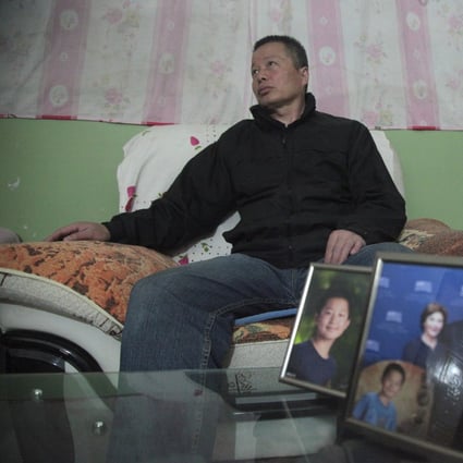 In this photo taken in 2015, Gao Zhisheng sits in a cave home in Shaanxi province. In the foreground are photos of his son and one of his daughter with former US President George Bush. Photo: AP