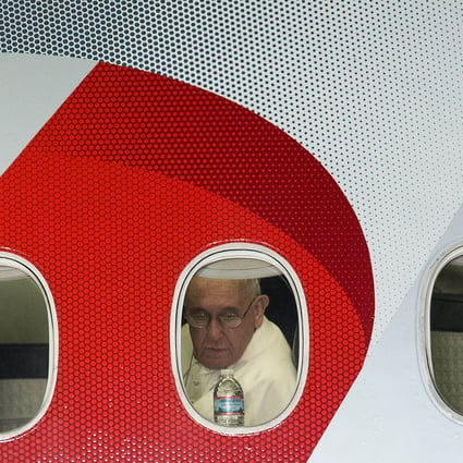 Pope Francis looks out his window as his plane leaves Philadelphia at the end of his six-day US visit on Sunday. He used the last day of the visit to meet victims of clergy sex abuse. Photo: AFP 