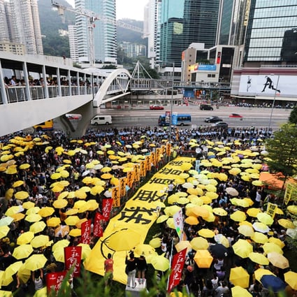 Yellow umbrellas once again make an appearance en masse outside government headquarters in Admiralty today along with a sign that reads “I want true universal suffrage” as rally participants commemorate the Occupy movement for genuine universal suffrage. Photo: Felix Wong