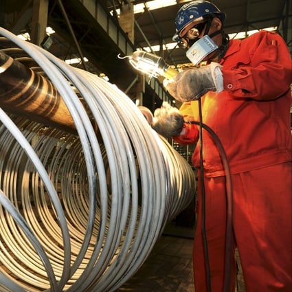 A worker polishes steel coils at a factory in Dalian, Liaoning province, China. Photo: Reuters