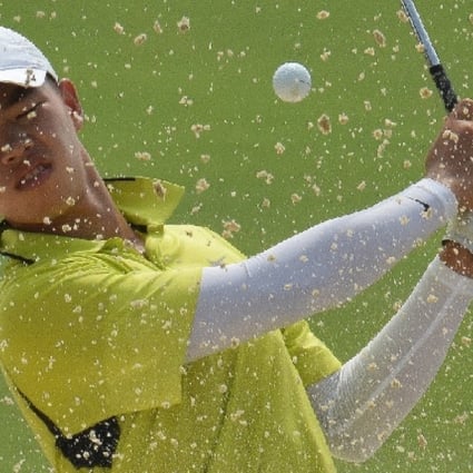 Guan Tianlang blasts out of a bunker at the 13th during a practice round on Wednesday. Photos: SCMP Pictures