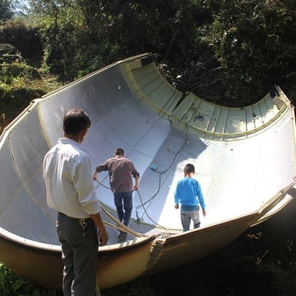 Farmers inspect the piece of space rocket that fell into their fields in Yuanxi village in Jiangxi province. Photos: SCMP Pictures