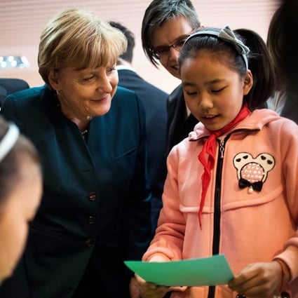 German Chancellor Angela Merkel talks to a student of the Jinputao school in Xinnacun village in the Baohe district of Hefei, China. Photo: AFP