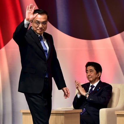 Premier Li Keqiang waves as he walks past Japan's Shinzo Abe and South Korea's Park Geun-hye at a summit in Seoul on Sunday. Photo: Reuters