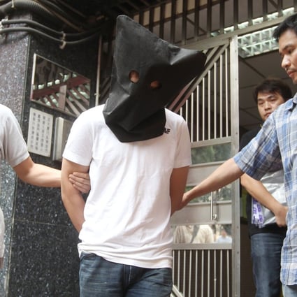 An alleged triad member is arrested in Tsuen Wan. The black hood is used to protect the suspect's privacy. Photo: Edward Wong/SCMP