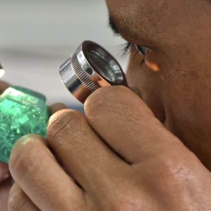 A worker looks at an emerald at the workshop of Muzo Emerald Company in Bogota, Colombia. Photo: AFP
