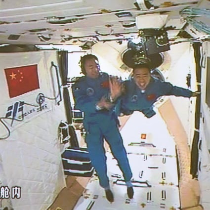 Chinese astronauts Jing Haipeng (left) and Chen Dong (right) entering the Tiangong-2 space lab on October 19, 2016. (Picture: Xinhua)