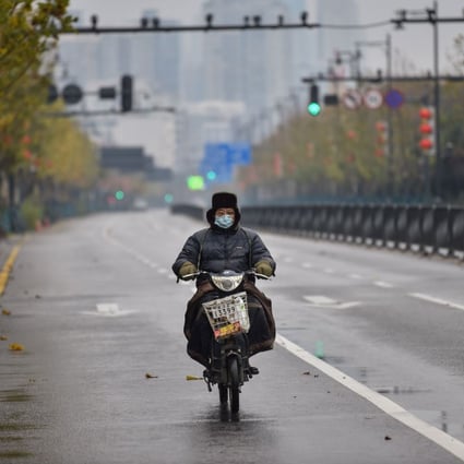 A man wearing a protective mask rides a motorcycle on a street in Wuhan on January 26. (Picture: Hector Retamal/AFP)