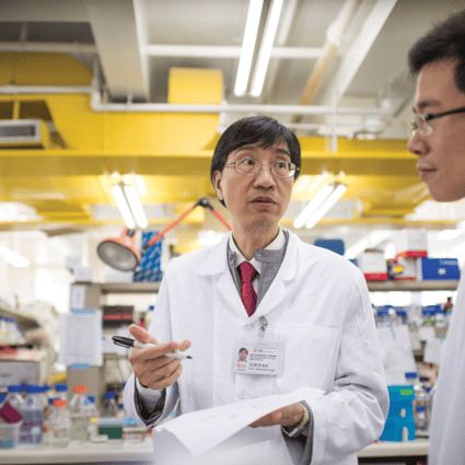 Professor YUEN Kwok-yung discusses with students in a laboratory.
