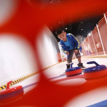 Raphael Siauw tries his hand at curling at the Winter Games exhibition at the Hong Kong Science Museum in 2019. Photo: David Wong