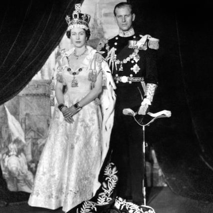 Queen Elizabeth II, wearing the Imperial State Crown, and her Coronation robes, with the Duke of Edinburgh, in uniform as Admiral of the Fleet, in the Throne Room of Buckingham Palace, London, after the Coronation. (Photo by PA Images via Getty Images)