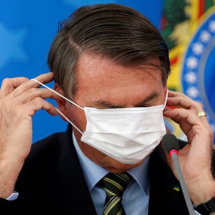 Brazilian President Jair Bolsonaro adjusts his face mask during a news conference in Brasilia, Brazil, on March 18, 2020. Under Biden, Bolsonaro’s far-right discourse is likely to fall on deaf ears. Photo: Reuters