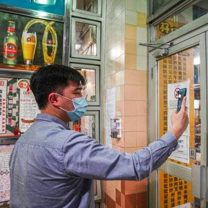 A man scans a QR code via the “Leave Home Safe” app to enter a restaurant in Wan Chai on February 18. Photo: Sam Tsang