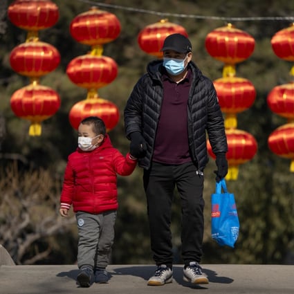 A man and child wear masks in a public park in Beijing. China has not lifted its birth rate more than four years after ending the one-child policy. Photo: AP 