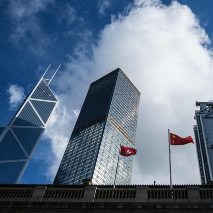 The Chinese national flag and the Hong Kong flag are flanked by skyscrapers housing the international banks and financial institutions that the city is famed for. Photo: AFP