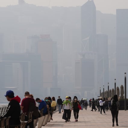 People stroll down the Tsim Sha Tsui waterfront promenade as Hong Kong Island is shrouded in smog on January 17. Photo: Sam Tsang