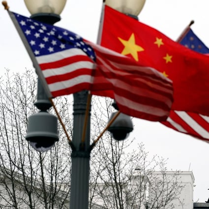 A Secret Service agent guarding his post on the roof of the White House forms the backdrop for a lamp post adorned with the Chinese and US national flags, in Washington. Photo: AFP 