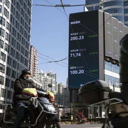 Motorists travel past a screen displaying stock figures in Shanghai, China. Photo: Bloomberg