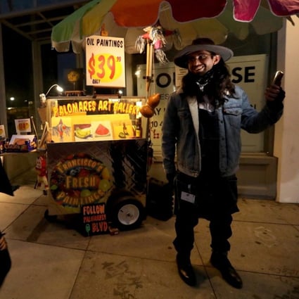 Artist Francisco Palomares stands in front of his converted fruit cart as pedestrians walk past on Traction Avenue in the Arts District, Los Angeles, the US. Photo: TNS