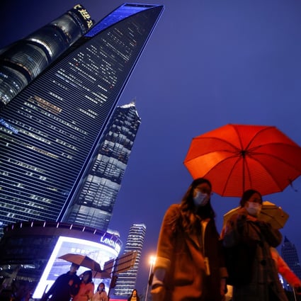 People walk with umbrellas in Lujiazui financial district in Pudong, Shanghai, on March 5. Photo: Reuters