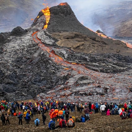 Sunday hikers look at the lava flowing from the erupting Fagradalsfjall volcano, 40 km west of the Icelandic capital, Reykjavik. Photo: Jeremie Richard/AFP