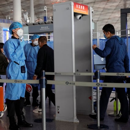 Medical staff check people’s temperature as they enter Beijing’s international airport on November 5, 2020. Photo: Reuters