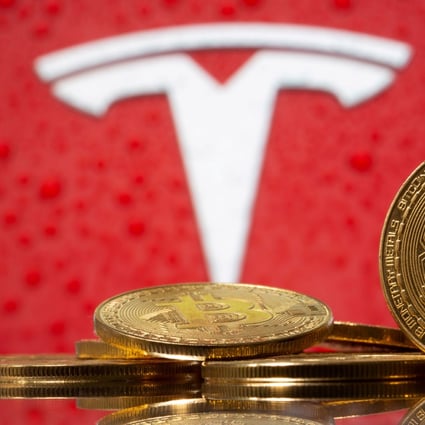 Representations of virtual currency bitcoin are seen in front of the Tesla logo. Photo: Reuters