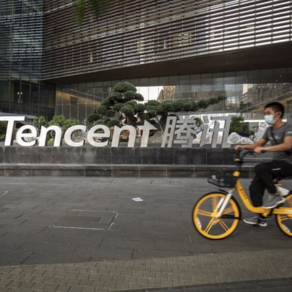 A cyclist wearing a protective mask rides past the Tencent Holdings logo at the company’s headquarters in Shenzhen on March 20. Photo: Bloomberg