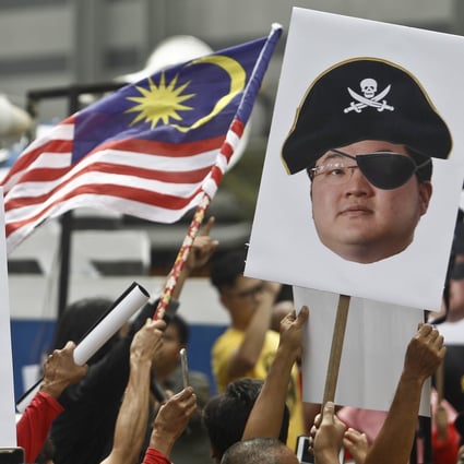 Protesters hold portraits of Jho Low in Kuala Lumpur, Malaysia. Photo: AP