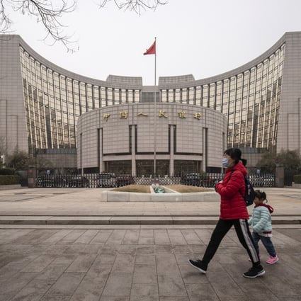 A woman and child walk past the People’s Bank of China building in Beijing, on March 4. Inflationary pressure is unlikely to be a concern for the central bank. Photo: Bloomberg