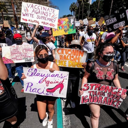 Demonstrators holding signs march during a rally against anti-Asian hate crimes outside City Hall in Los Angeles, California, on March 27. Photo: Reuters