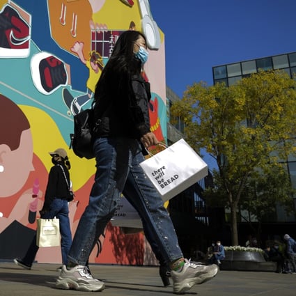 Women walk past a popular shopping mall in Beijing, on October 19, 2020. China’s economic recovery from the coronavirus pandemic is gaining strength as consumers return to shopping malls and auto dealerships. Photo: AP
