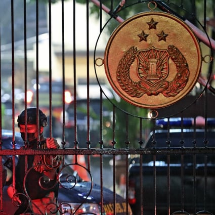 Police officers stand guard at the main gate of the National Police Headquarters in Jakarta following a suspected militant attack. Photo: AP