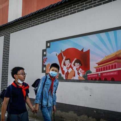 Chinese boys pass a patriotic banner as they walk home together after school on September 17, 2020, in Beijing. For a hybrid foreign-Chinese education model to work, it must be based on China’s excellent traditional culture. Photo: Getty Images